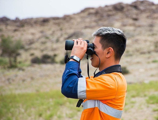 man looking through binoculars